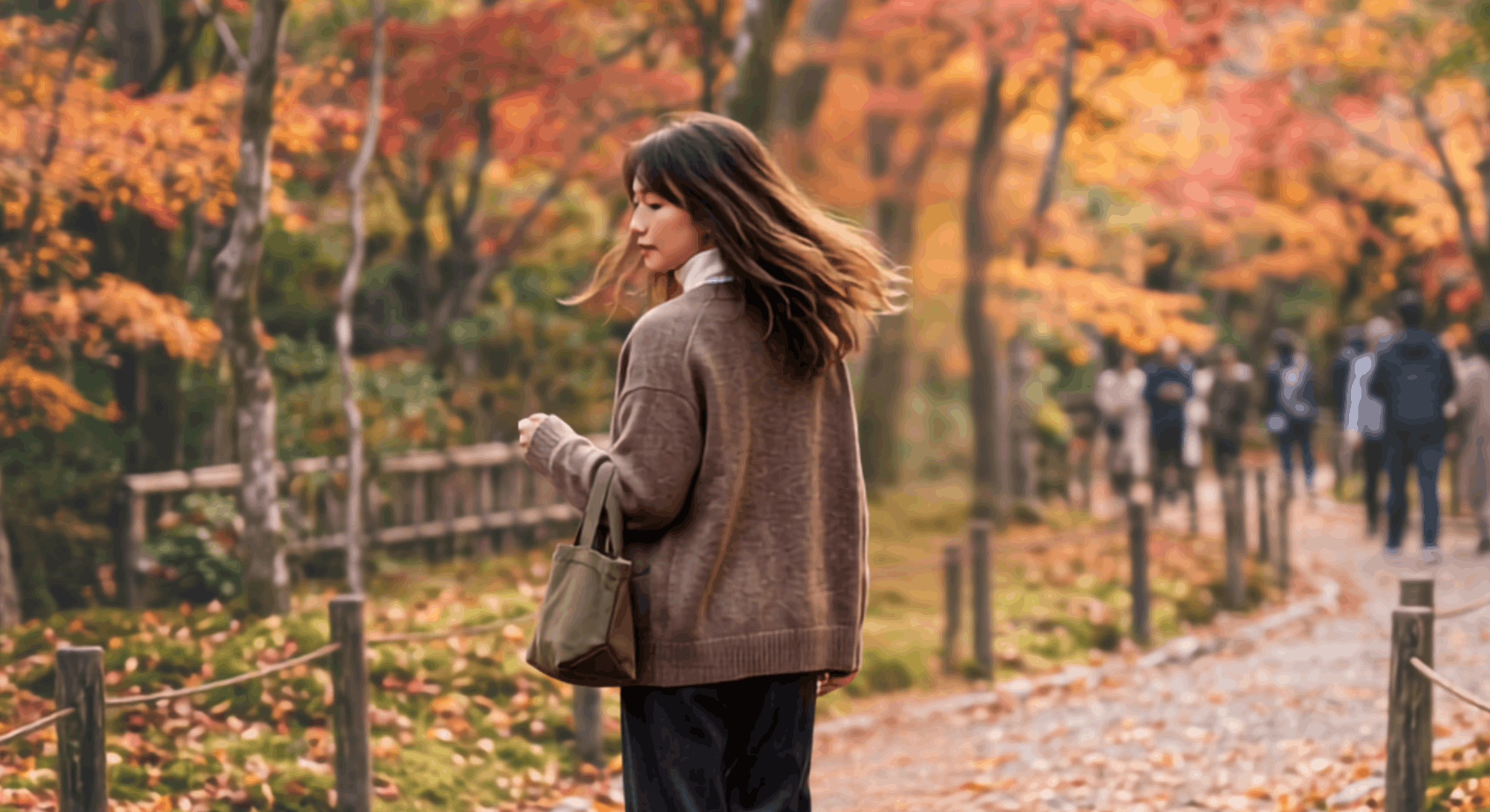 紅葉の道を歩く女性